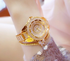 Close-up of luxury gold women's watch encrusted with sparkling rhinestones on wrist