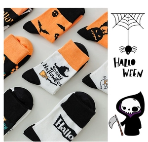Detail of Halloween socks showing knitted pumpkin, bat and wizard motifs in classic colors