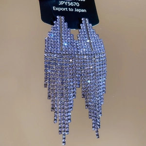 Macro detail of silver needle drop earrings with lavender crystals and tassels