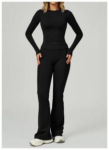 Detail eines schwarzen Yoga-Sets mit seitlicher Raffung und ausgestellter Fitnesshose