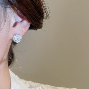 Close-up of sparkling cubic zirconia round drop earring on model with silver pin