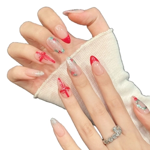 Faux ongles amande de Noël avec pointes françaises rouges et motifs de couronne