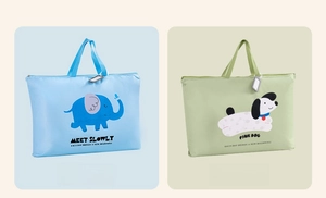 Detail view of large quilt storage bags with elephant and puppy prints and handles