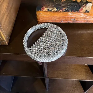 Detail of silver metallic beaded handmade woven half-moon handbag with a round handle