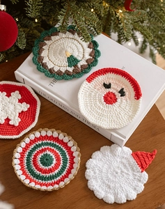 Close-up of five diverse Christmas crochet coasters on a festive warm wooden table