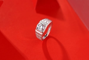Macro shot of 925 sterling silver men's ring with a large moissanite on red background