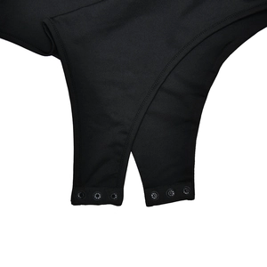 Close-up of the snap button closure on the bottom of a black V-neck bodysuit
