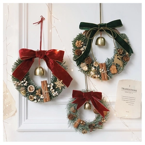 Detail of Christmas wreath with red velvet bows, pine cones, bells and cinnamon sticks