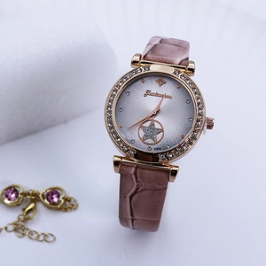 Close-up of elegant women's watch with rhinestone bezel and pink leather strap
