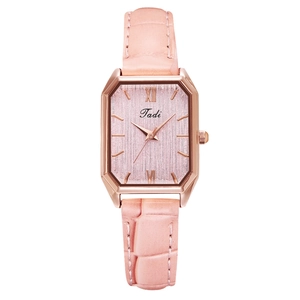 Detail of pink leather strap with crocodile pattern and rose gold square quartz watch