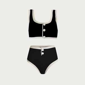Detail of minimalist two-piece swimsuit featuring decorative white buttons and ribbed texture