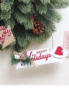 Gros plan d'une plaque de Noël en bois avec aiguilles de pin et pommes de pin