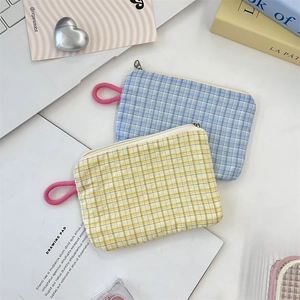 Close-up of blue and yellow checkered mini pouches with pink loops and metal zippers