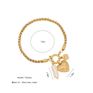 Dettaglio del bracciale in acciaio inossidabile dorato con cuore e perle bianche