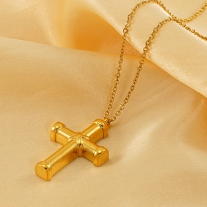 Elegant gold plated cross necklace on luxury silk background for women's fashion