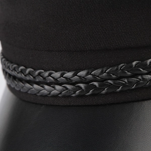 Close-up of braided rope detail and leather brim on a vintage black navy baker boy hat