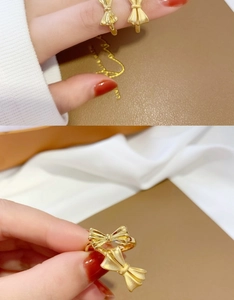 Detail of gold bow rings showing matte and polished textures on dark leather and silk