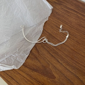Minimalist S925 sterling silver geometric knot bracelet with adjustable chain on a desk