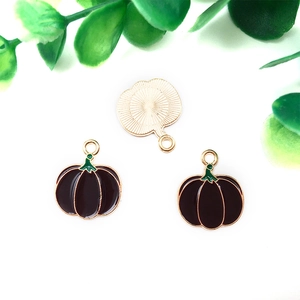Detailed view of pumpkin charms with purple enamel and gold finish for DIY crafts