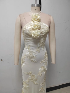 Detail of 3D floral accents and delicate lace embroidery on ivory halter gown