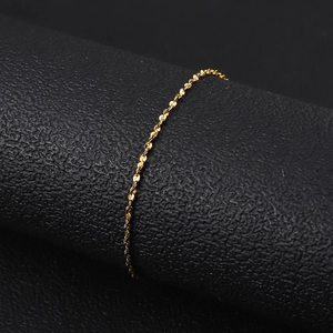 Close-up of a delicate 18K gold-plated titanium steel water wave chain on a black stand
