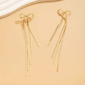 Detailed view of elegant gold bow earrings featuring dangling multi-strand metal chains