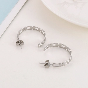 Detailed macro view of silver C-shaped hoop earrings featuring hollow chain link design