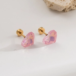 Détail de boucles d'oreilles cœur en zircon rose avec clous en acier doré à vis