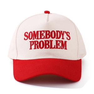 Close-up of red 'SOMEBODY'S PROBLEM' embroidery on a two-tone cotton baseball cap