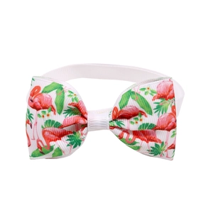 Detail of pink flamingo and green leaf pattern on pet bowtie with white elastic band