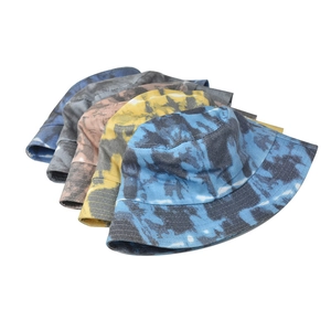 Detail showing five tie-dye bucket hats in various colors with wide brims and cotton texture