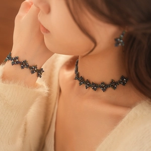 Detailed view of iridescent blue and green beaded choker and matching bracelet set
