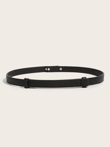 Detail of a thin black Saffiano leather belt with a minimalist metal snap button closure