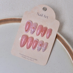 Macro view of 3D floral press-on nails with zebra stripes and gold beads on a soft tray