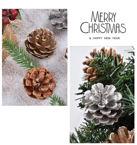 Detail of Christmas pine cones set with gold and silver spray and festive red berries