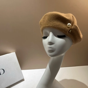 Close-up of camel wool beret featuring elegant pearl and gold bead side accents