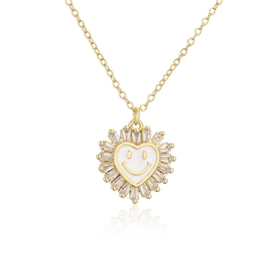 Macro view of golden heart pendant with white enamel smiley face and sparkling zircons