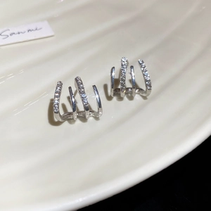Close-up of double-layer silver-toned C-shaped earrings with shimmering cubic zirconia