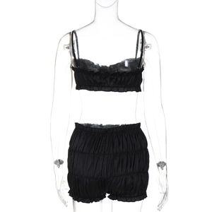 Detail of black two-piece satin lingerie set with ruffled tube top and matching shorts