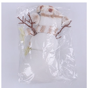 Détail d'un bonhomme de neige en peluche dans un sachet avec bonnet à carreaux marron