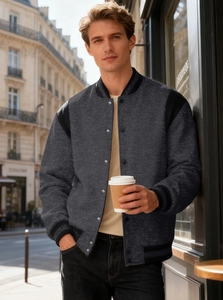 Detail of grey men's baseball jacket featuring contrast black sleeves and metal snap buttons