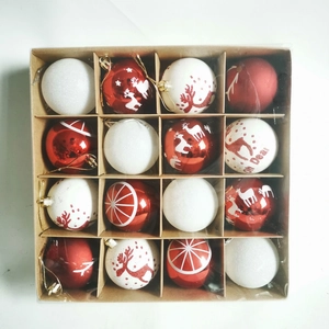 Top view of 16 red and white hand-painted Christmas balls with reindeer patterns in a box