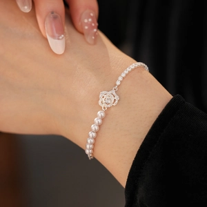 Detailed shot of pearl and zircon floral bracelet on wrist with elegant rose centerpiece