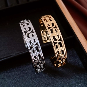 Close-up of hollow-out CD pattern bracelets in gold and silver finish on a display tray