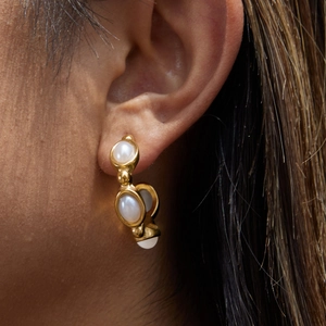 Detailansicht eines goldenen C-Form Ohrrings mit drei ovalen Perlen am Modell