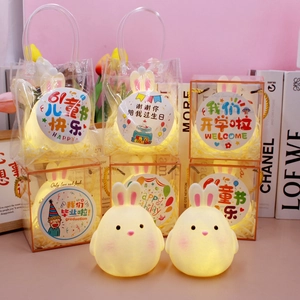Detail of warm glow bunny night light in various gift packaging and decorative themes