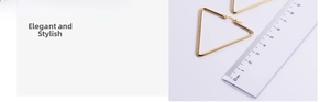 Close-up of golden triangle earrings showing a 5cm width measurement on a ruler