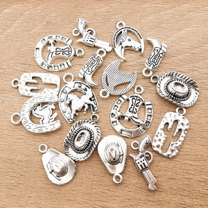 Detail view of vintage silver alloy charms featuring western cowboy hat and cactus shapes