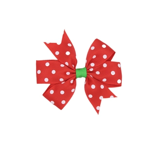 Detailed close-up of a red and white polka dot ribbon bow hair clip for Christmas decor
