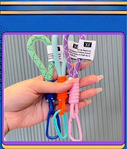 Macro detail of multi-color woven nylon keychains with metal snap hooks and tags
